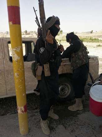 <p>Militantes do Estado Islâmico de guarda em ponto de controle em Khazer, na fronteira da região do Curdistão, em 7 de julho</p>