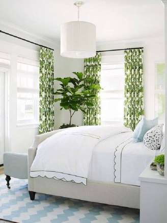 1. Decoração leve com lustre para quarto de casal todo branco com detalhes em verde – Foto: The Everygirl