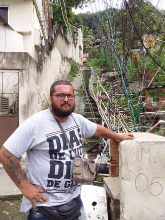  Rafael Amorim ajuda seus vizinhos a receber água na comunidade Camarista Meier, na zona norte da cidade