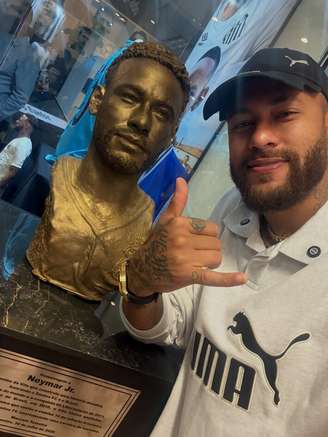 Neymar posa ao lado de busto que recebeu em homenagem no Memorial do Santos