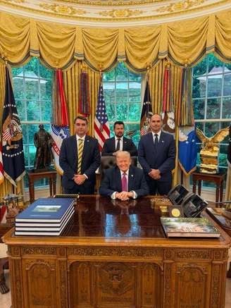 Imagem de Flávio Bolsonaro, Paulo Figueiredo e Eduardo Bolsonaro ao lado de Donald Trump