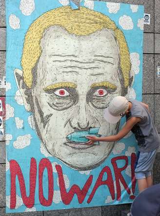 <p>Na foto, um menino observa um cartaz com uma caricatura do presidente russo, Vladimir Putin, pedindo "Não à guerra", na Praça da Independência de Kiev, na Ucrânia, em 6 de julho</p>