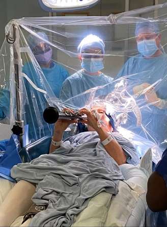 Paciente toca clarinete enquanto passa por procedimento no cérebro para tratar Parkinson