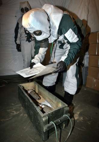 <p>Um especialista em armas químicas abandonadas japonês embala armamento escavado em frente a uma escola em Mudanjiang, província de Heilongjiang, nordeste da China, em julho de 2006 </p>