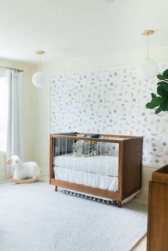 1. Berço de madeira para quarto de bebe branco decorado com papel de parede delicado – Foto: Little Crown Interiors