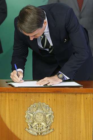 O presidente Jair Bolsonaro (PSL) assina o decreto da flexibilização de compra de arma de fogo e munição no País