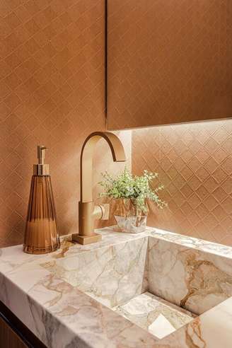 1. Banheiro luxuoso com cuba de mármore e detalhes em dourado – Via: ARD Studio
