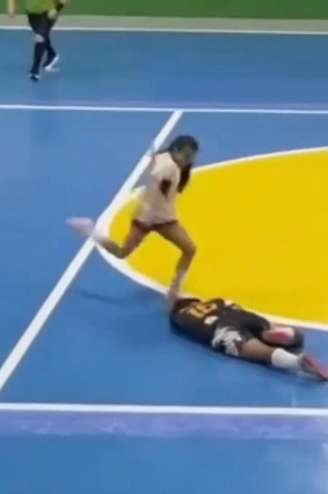 Jogadora chuta a cabeça de adversária caída no chão.
