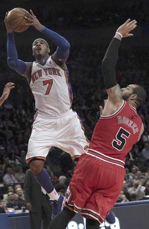Carmelo Anthony (7) de los Knicks de Nueva York penetra a la canasta ante la marca de Carlos Boozer de los Bulls de Chicago el domingo 8 de abril de 2012. Foto: Mary Altaffer / AP